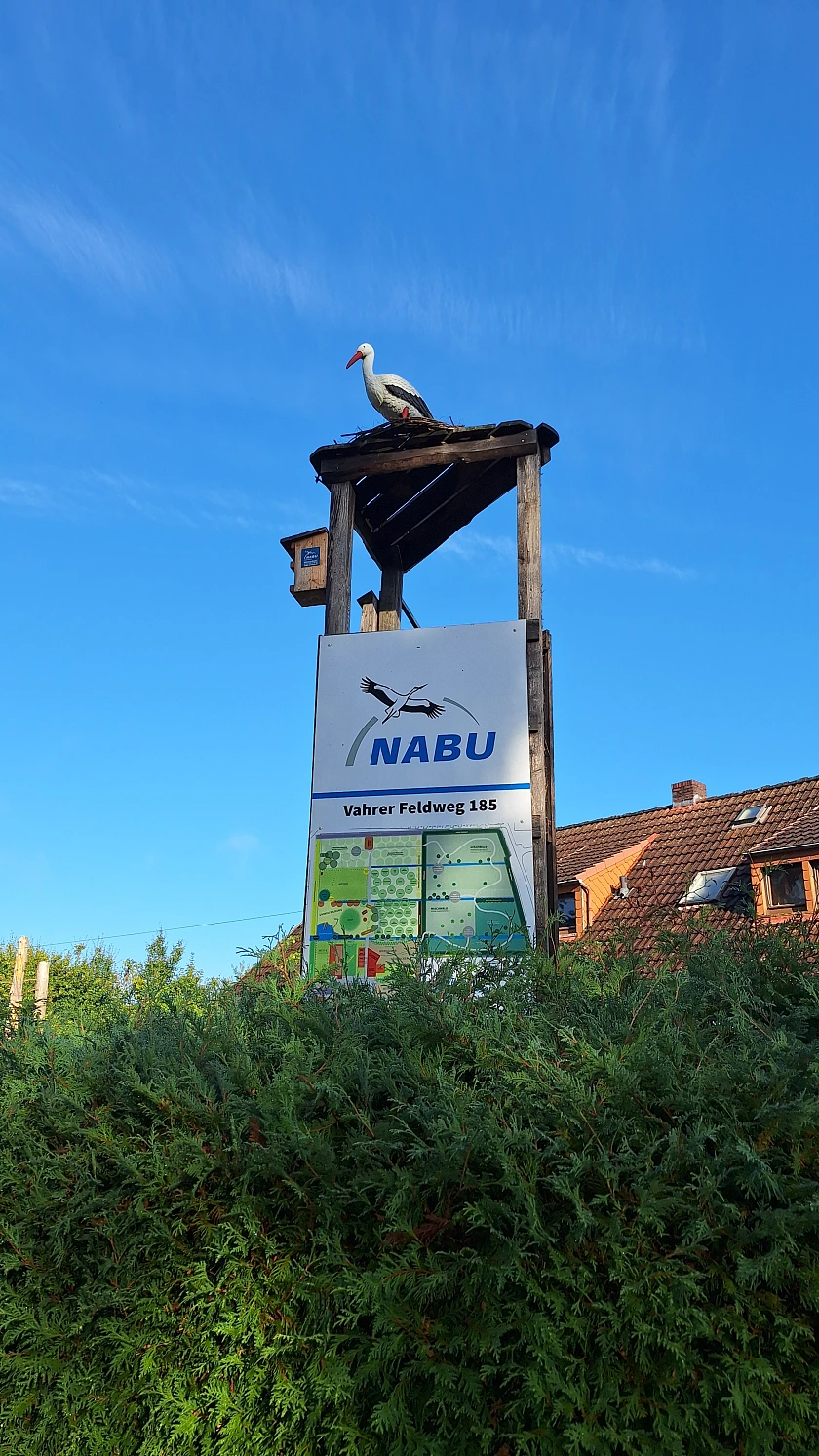 Säule neben dem Eingang zum NABU Bremen, auf der Säule ist ein Storch zu sehen