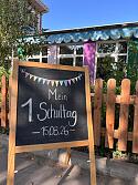 Kreidetafel vor dem Schulgarten. Auf der Tafel steht: 1. Schultag 15.08.2026